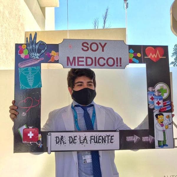 Exalumno con cartel Soy Médico