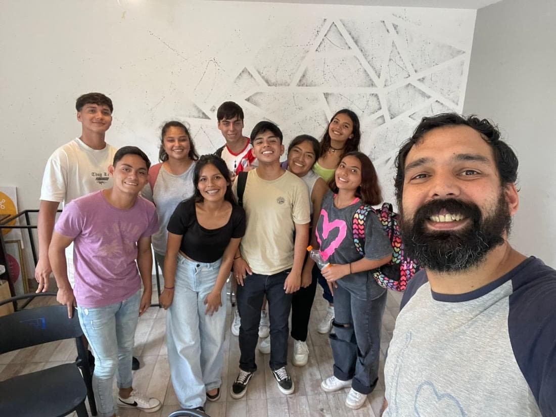 Estudiantes sonriendo junto al profesor